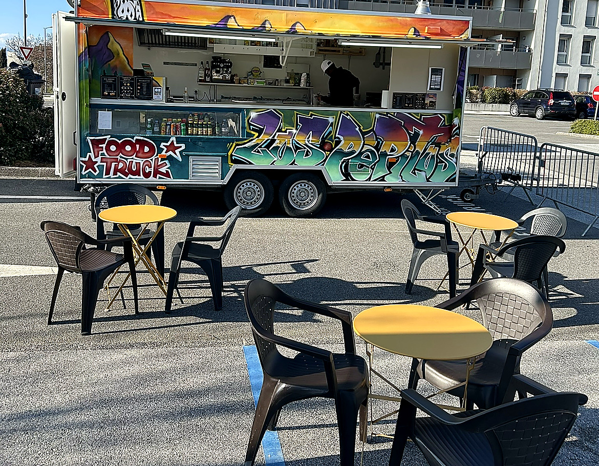 Tables et chaises devant la remorque Los Pepitos, pour manger sur place